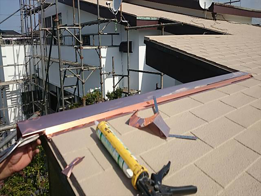 浮きがあった屋根板金。新しい板金の形とサイズを合わせた後、釘で留め付けます。