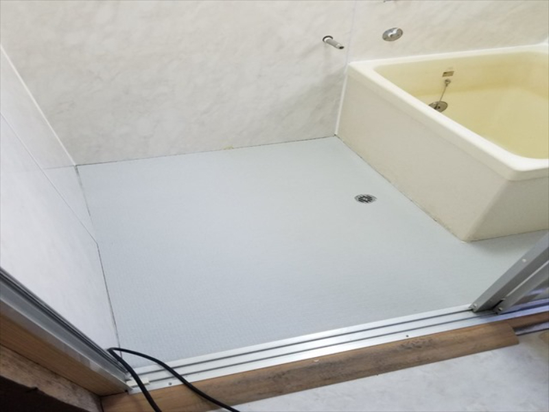 灰色の浴室専用床材が貼られた浴室