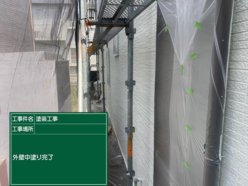 養生した窓と塗装された外壁