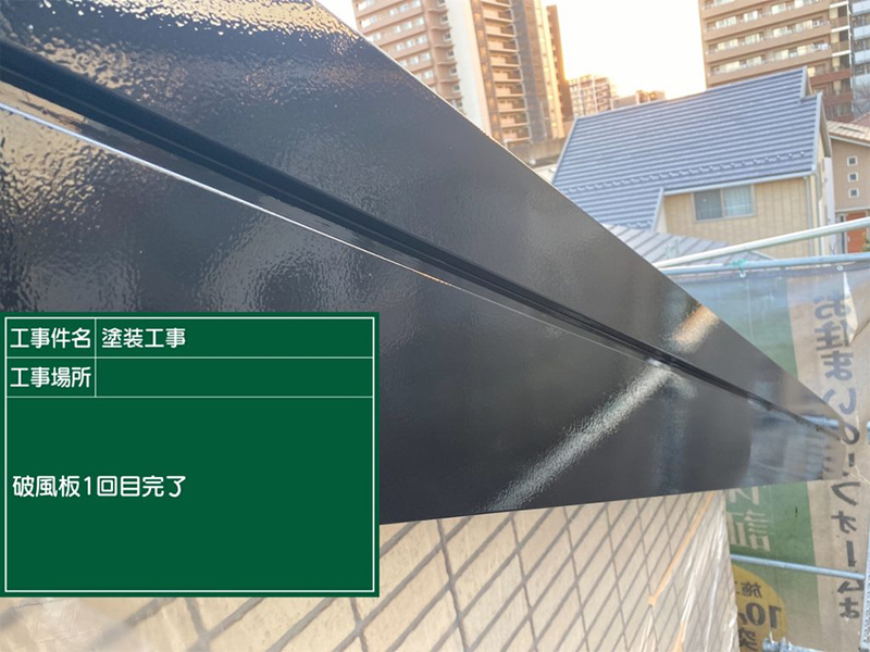 黒く艶が出た破風板。屋根の向こうにはマンションと隣家が見える