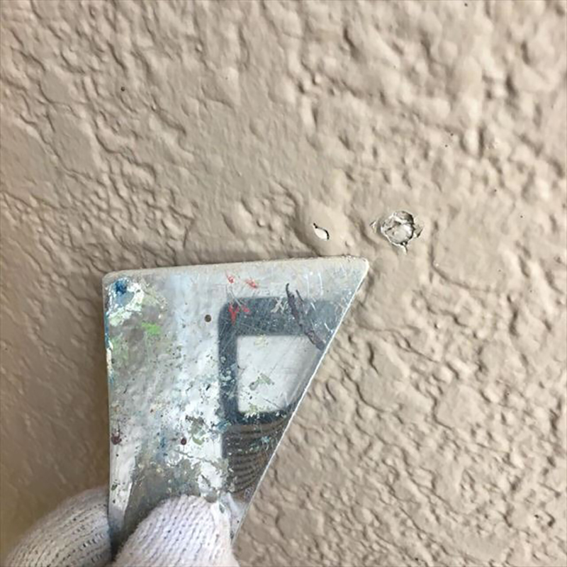 外壁に膨れが出ていたので、削り落としました。以前の塗装で、弾性系の塗料が塗ってあり、内部結露の影響でフクレが出ていました。