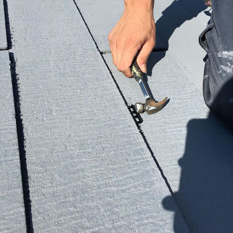 屋根上塗り1回目が終わったらタスペーサーを使用していきます。  このタスペーサーは、雨漏りをしないようにするために挿入します。