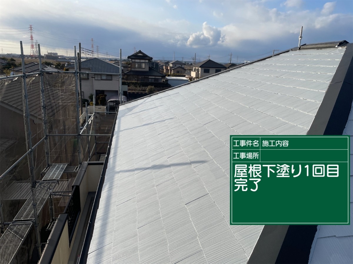 スレート屋根の下塗り1回めが完了して屋根全体が白っぽく塗られている様子