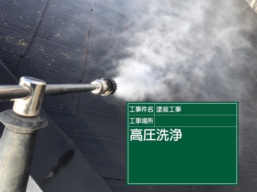 高圧洗浄機から煙のような水が出てスレート屋根を洗浄している様子