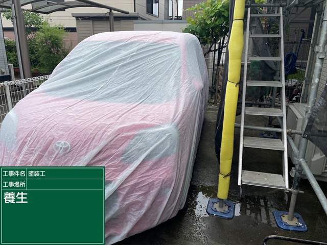 足場横にある赤い車がシートで覆われている